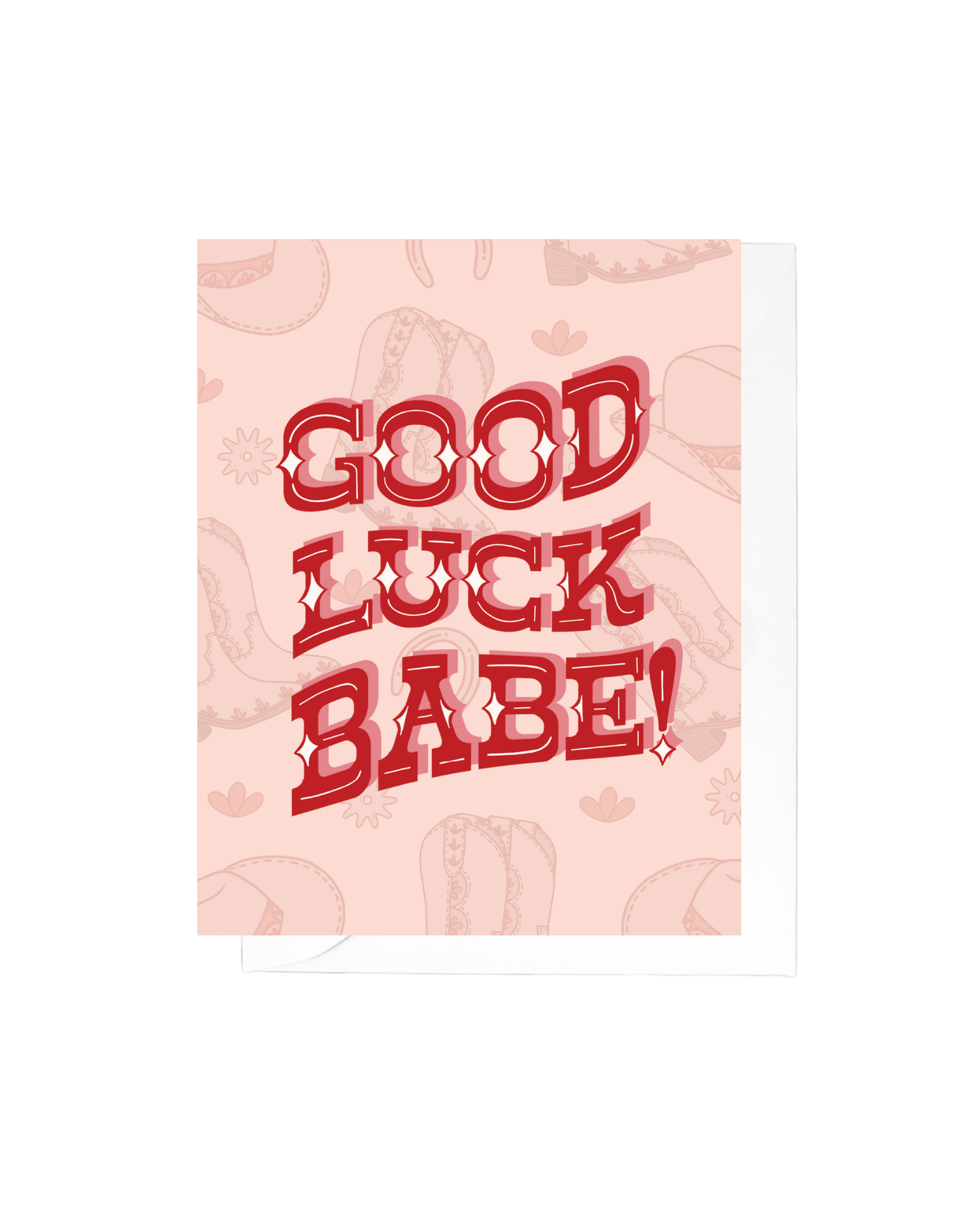 Pink greeting card with boots and cowgirl hat illustrations and the words good luck babe in a red, western-inspired font in the center of the card