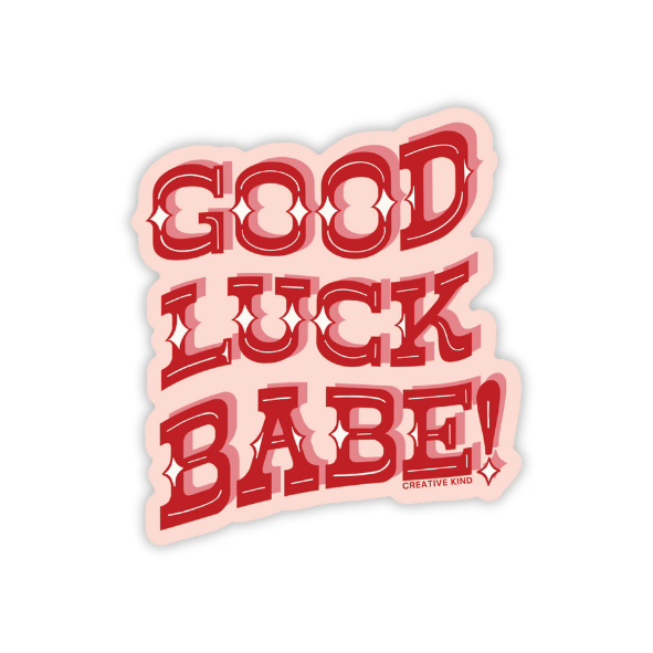 Die cut light pink sticker with the words Good Luck Babe in a wavy, red, western-inspired font